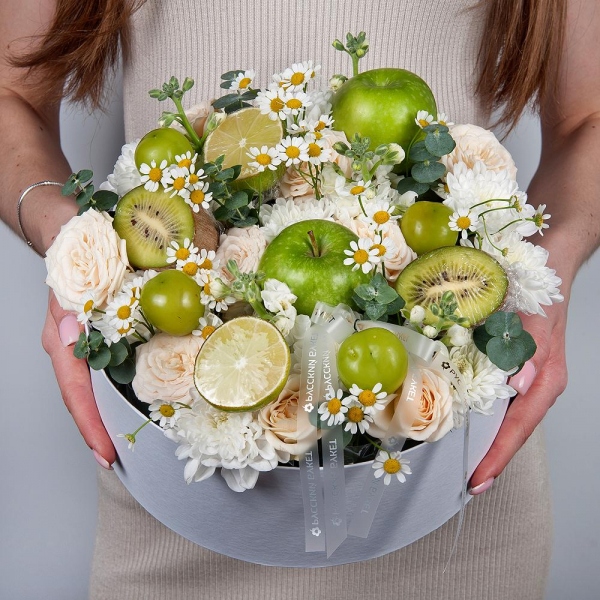 Baltica White Spray Chrysanthemum - 1, White Matthiola - 4, Peony sprayrose - 3, Chamomile - 3, Circular arrangement box, Oasis, Eucalyptus, Kiwi, Apple, 1 pc., Lemon, 1 pc., Grapes, Wooden skewer, Grapes, Ribbon