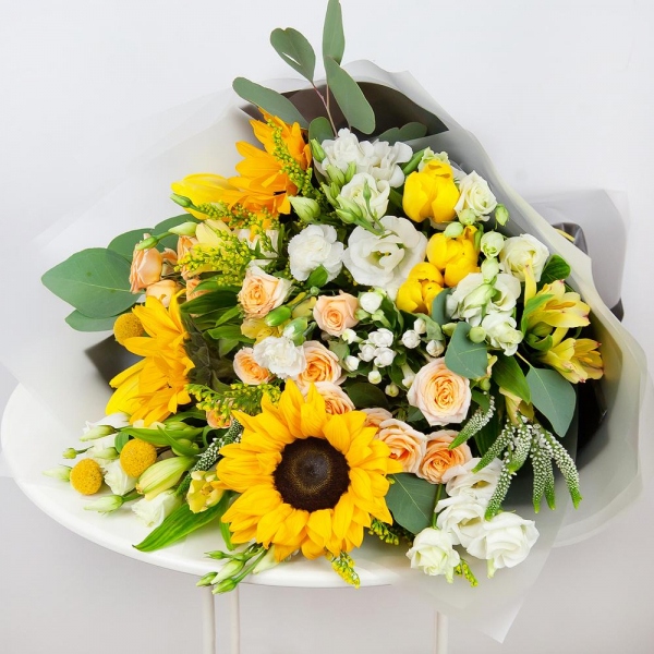 Sunflower - 5, Spray rose: white, cream, light pink 50 cm - 5, lisianthus - 5, Alstromeria Yellow, Orange - 5, Tulip white - 7, White spray carnation - 4, Solidago (1 pc.), Veronica spray, Craspedia, Pistachio, Eucalyptus populus (1 pc.),  Bouvardia, Wrapping Paper, Ribbon