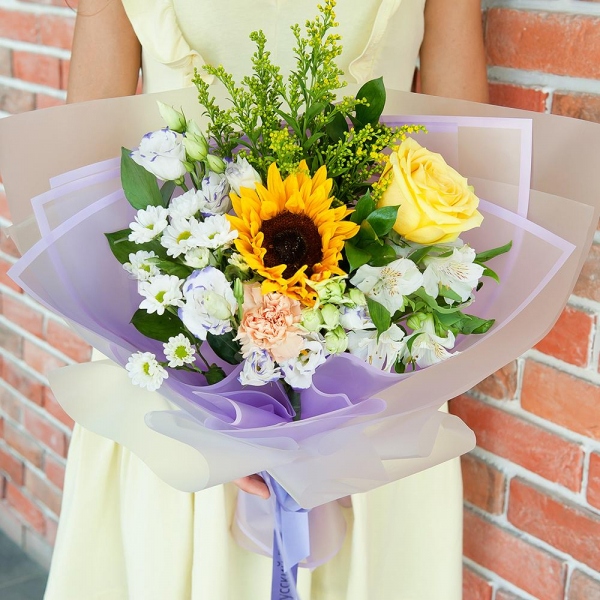 Sunflower - 1, Yellow rose 50 cm - 2, Carnation white, cream - 1, Santini White Spray Chrysanthemum - 2, Alstromeria white, soft pink - 1, lisianthus - 2, Solidago (1 pc.), Ruscus, Ribbon, Wrapping Paper