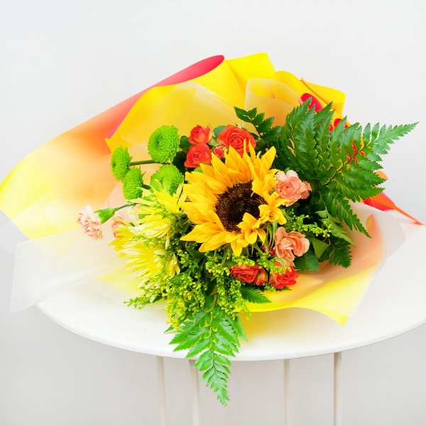 Sunflower - 1, Baltica Yellow Spray Chrysanthemum - 2, Spray rose: yellow, orange 50 cm - 3, Pink spray carnation - 3, Athos pom Feeling Green - 1, Solidago (1 pc.), Fern (1 pc.), Wrapping Paper