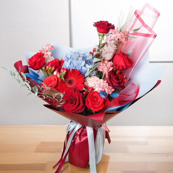 Blue/purple hydrangea - 1, Pink carnation - 7, Red rose 50 cm - 9, Rose Cream 50 cm - 4, Gerbera red - 1, Hypericum, Ruscus italian, Dried flowers in assortment, Wrapping Paper
