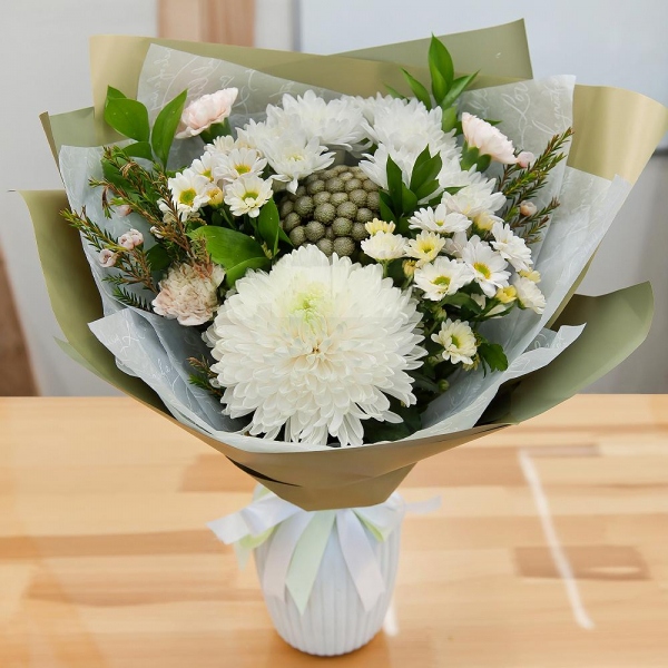 Magnum White Chrysanthemum - 1, Baltica White Spray Chrysanthemum - 2, Carnation white, cream - 5, Santini White Spray Chrysanthemum - 2, Brunia Green Lanuginosa (1 pc.), Waxflower (1 pc.), Ruscus, Wrapping Paper, Ribbon